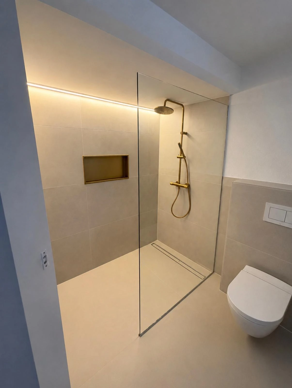 Badezimmer mit bodengleicher Dusche und beleuchteter Nische
